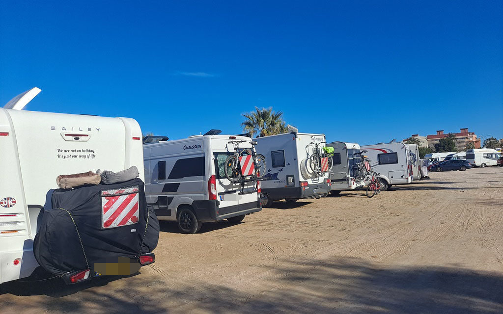 Mehr als 40 Wohnmobile nehmen in Denia den Parkplatz am Strand